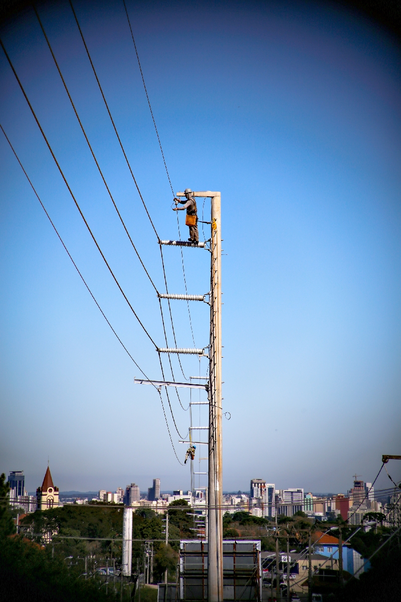 Técnicos instalam fiação em superpostes no bairro Abranches, em Curitiba: reajuste menor da tarifa compromete previsão de investimentos da Copel | Daniel Castellano/ Gazeta do Povo