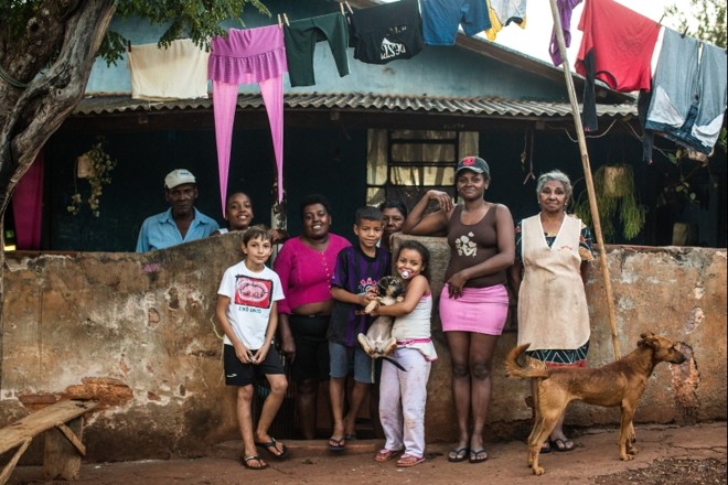 Família em frente à casa: Flozindo, Emily, Marilena e Marinete (ao fundo). Na frente, um vizinho, um dos netos, Nicole, Regiane e dona Ana |