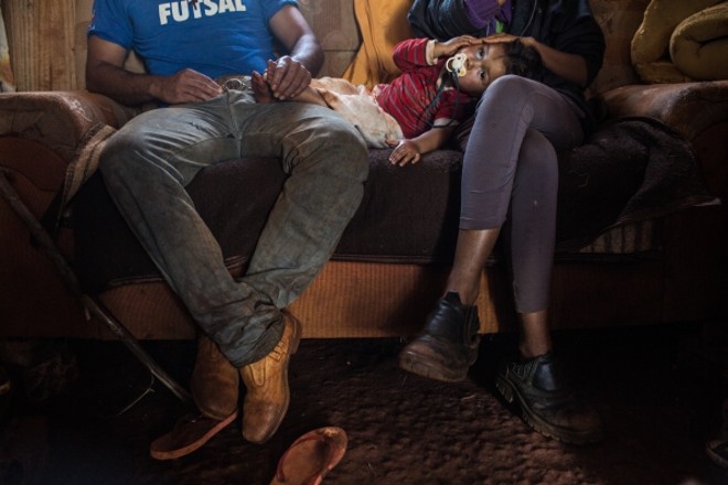 Eloar, olho pintado com maquiagem, aproveita o colo do pai e da mãe durante a entrevista |