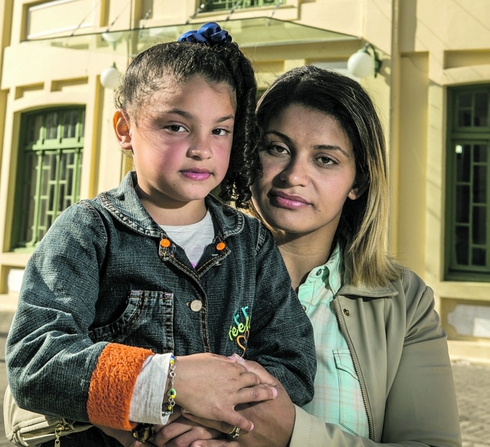 Renata e sua filha Evelyn, em frente do Hospital Cesar Pernetta, anexo do Pequeno Príncipe: viagens semanais a Curitiba para tratar da filha por falta do atendimento de que a menina necessita em Maringá | Marcelo Andrade/ Gazeta do Povo