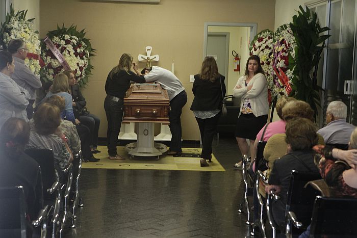 A viúva de Marcos Martins, Flavia, se debruça sobre o caixão do marido | Walter Fernandes / Gazeta do Povo