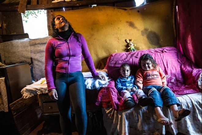 Cobertores são usados pela família para diminuir o vento dentro de casa devido ao espaço entre as tábuas de madeira | 