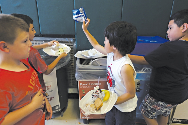 Alunos separando sobras do almoço que se tornarão adubo num aterro sanitário de Nova York | Hiroko Masuike/The New York Times