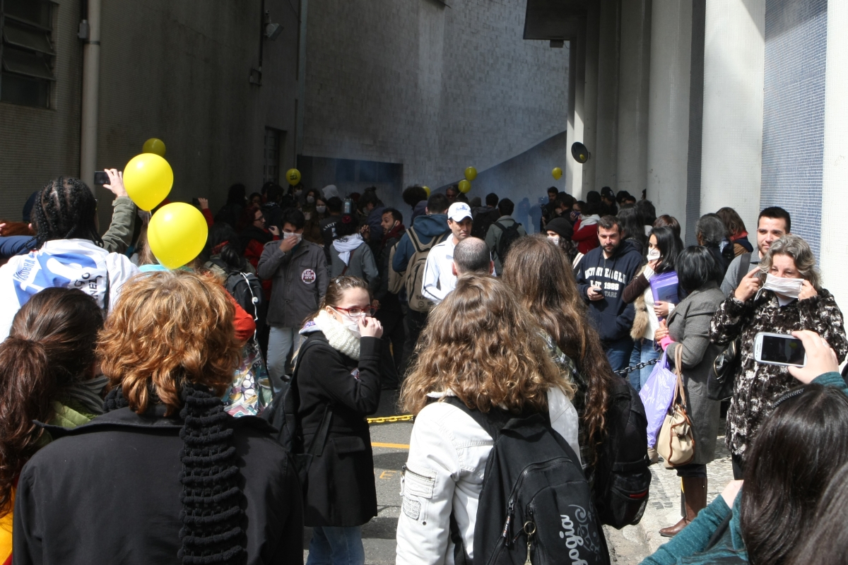 Participantes do protesto se protegem durante a dispersão de spray de pimenta por parte da Polícia Federal | Aniele Nascimento/Agência de Notícias Gazeta do Povo