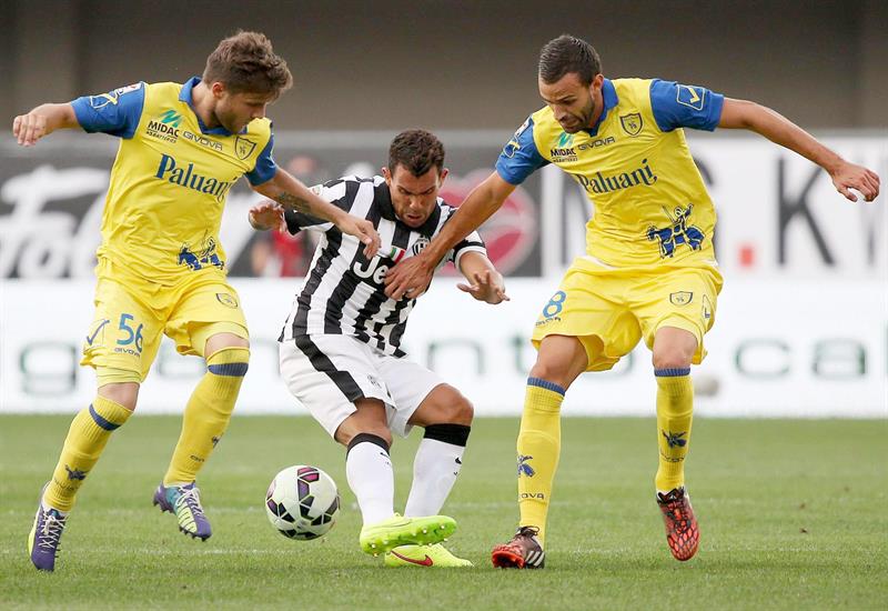 Carlos Tevez (centro), da Juventus, briga pela bola em jogada com Perparim Hetemaj (à equerda) e Ivan Radovanovic, do Chievo | EFE/EPA/VENEZIA