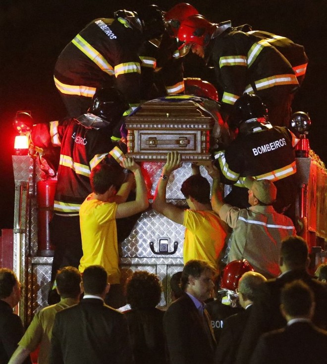 Os filhos João e Pedro ajudam a colocar o caixão do pai, Eduardo Campos, sobre o carro do Corpo de Bombeiros |
