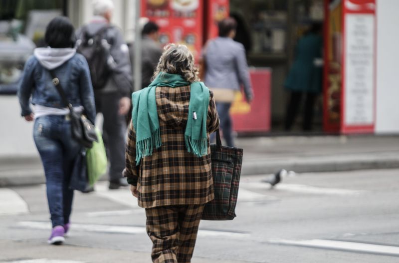 Transeunte se protege do frio, em Curitiba | Daniel Castellano / Gazeta do Povo
