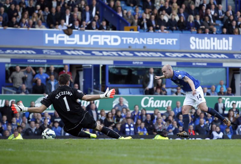 Steven Naismith (à direita), do Everton chuta contra o gol do Arsenal durante partida deste sábado | REUTERS/Andrew Yates
