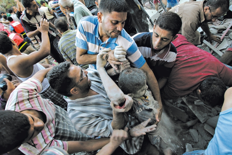 Palestinos evacuam um menino ferido depois dos ataques aéreos israelenses realizados para libertar um soldado que teria sido sequestrado | Eyad Baba/Associated Press