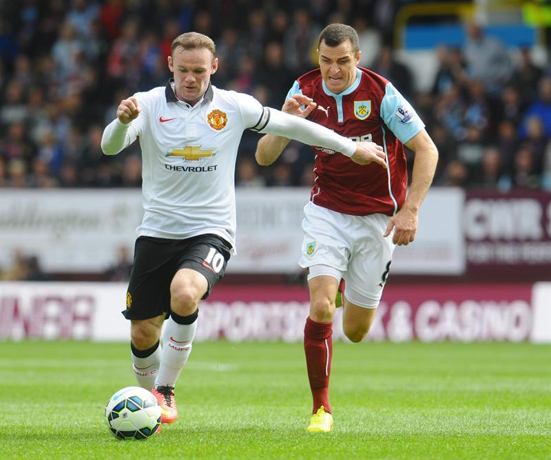 Wayne Rooney (à esquerda), do Manchester United, disputa a bola com Dean Marney, do Burnley, durante partida pelo Campeonato Inglês | EFE/EPA/PETER POWELL