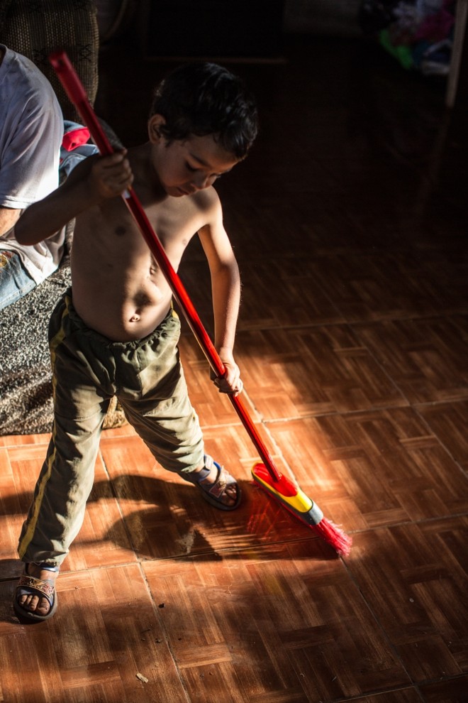 O menino finge varrer a casa | 