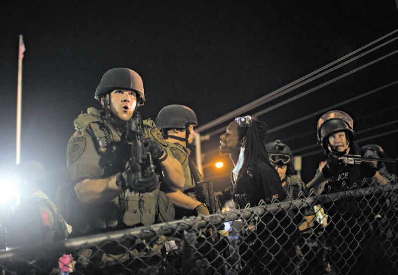 Obama pediu uma revisão dos programas que fornecem armamentos militares a polícias locais. Confronto em Ferguson, Missouri | Eric Thayer para The New York Times