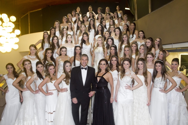 O presidente do Clube Curitibano, José Antônio Baggio, e a primeira-dama, Andrea Baggio, com as 61 debutantes na luxuosa festa do último sábado. A decoração contou até com aroma de notas de limão siciliano para remeter ao tema da noite, um jantar no jardim. Bouganvilles desidratados deram o tom do décor, além do mix de rosas, orquídeas e callas verdes | Gustavo Garrett