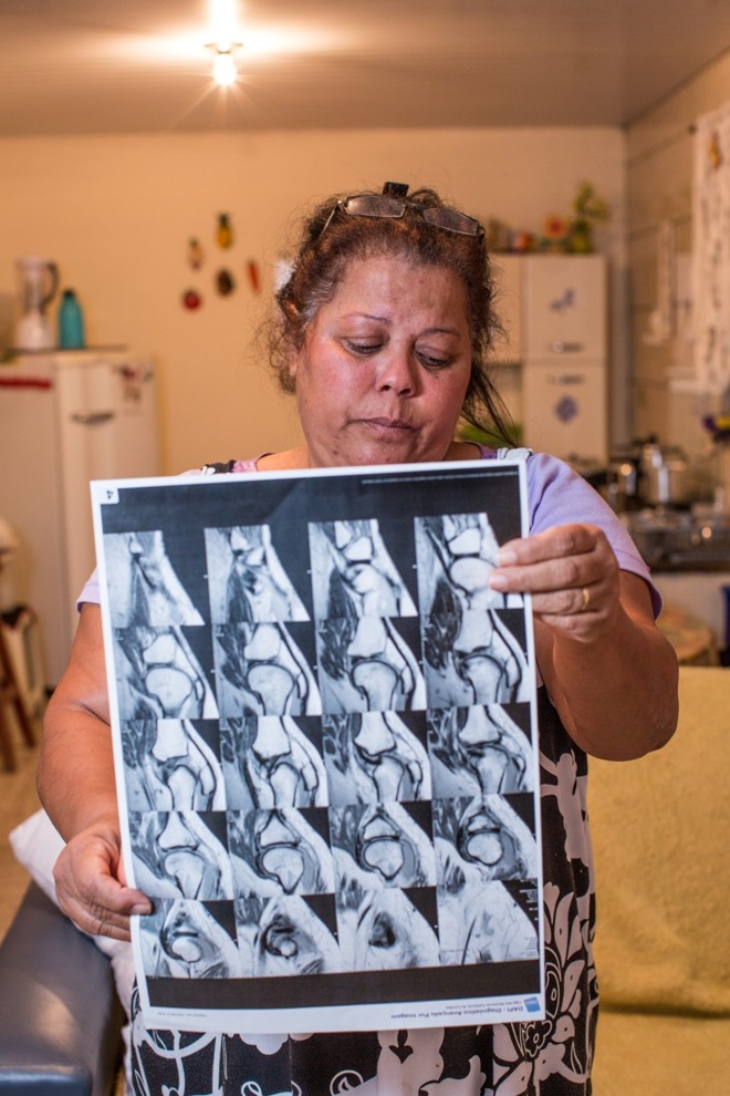 Em pé, Marlene mostra exame |