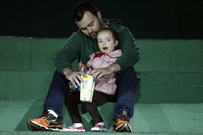 Um tempinho no jogo para o papai cuidar da pequena filha coxa-branca na arquibancada do Couto Pereira | 