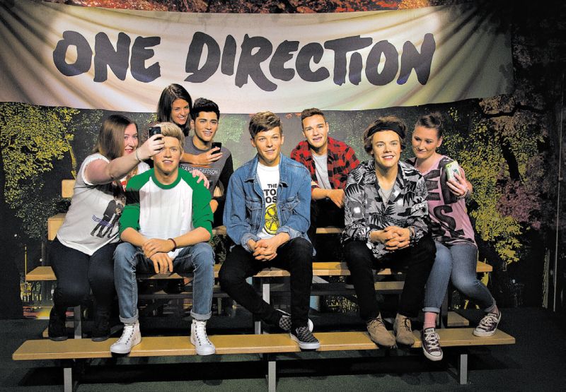 Fãs tiram fotos com estátuas de cera dos integrantes do One Direction, banda citada na edição 2015 do Guinness World Records | Joel Ryan/Invision/AP