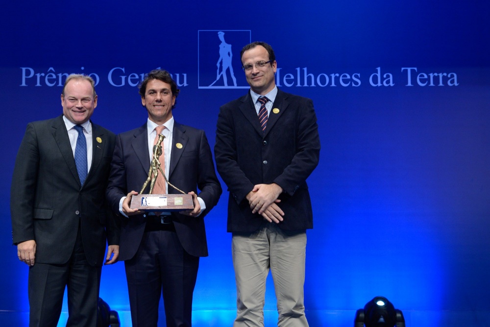 André Gerdau (esquerda) e secretário da Agricultura, Pecuária e Agronegócio do RS, Carlos Fioreze, entregam troféu ouro da categoria destaque ao presidente da New Holland, Alessandro Maritano (meio). | Divulgaa§a£o