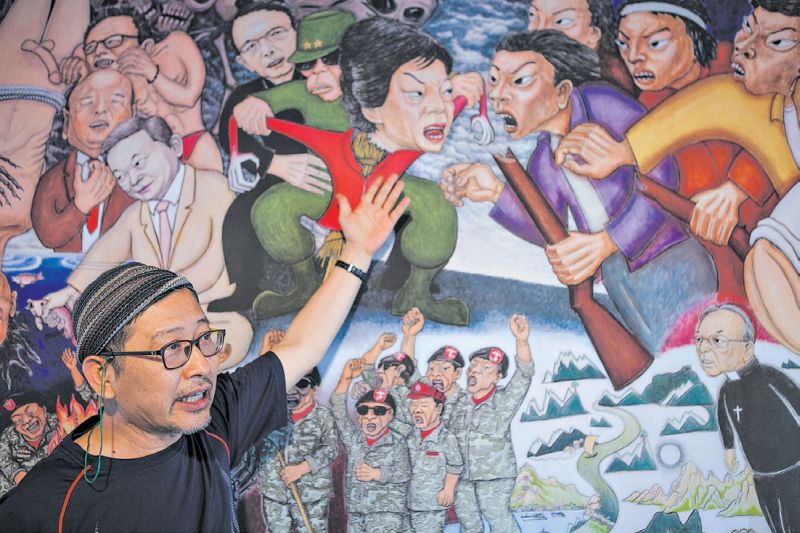 Hong Sung-dam com uma réplica de sua tela Sewol Owol, criticada por parodiar a presidente Park Geun-hye | Jean Chung para The New York Times