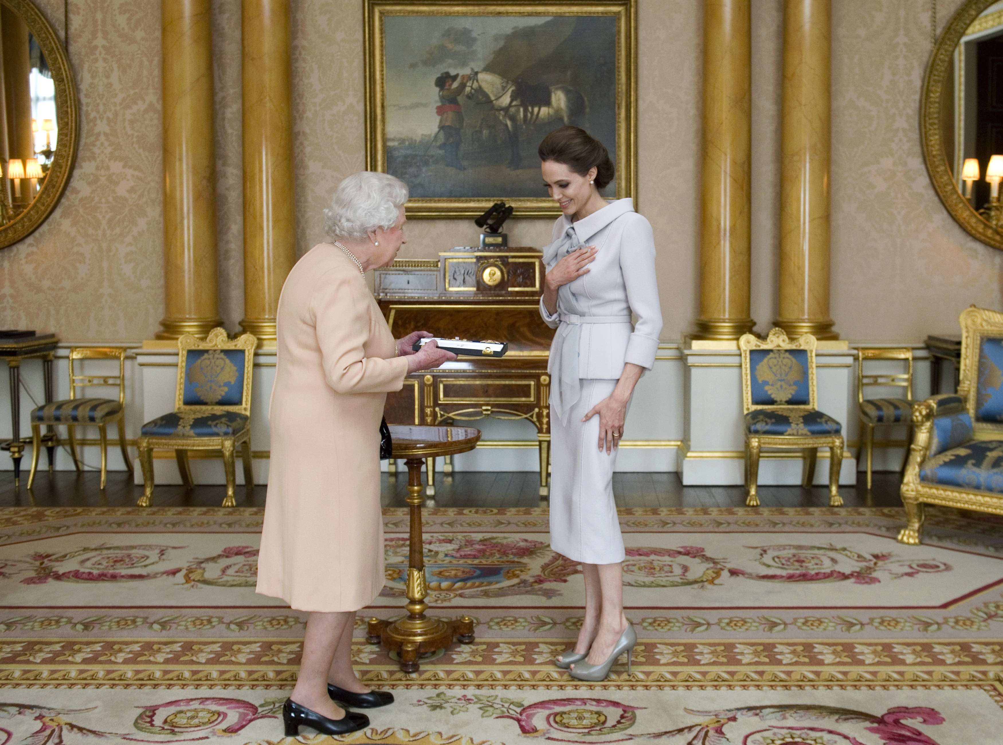Angelina Jolie recebe a honraria da rainha Elizabeth, em uma cerimônia particular no Palácio de Buckingham. | Reuters