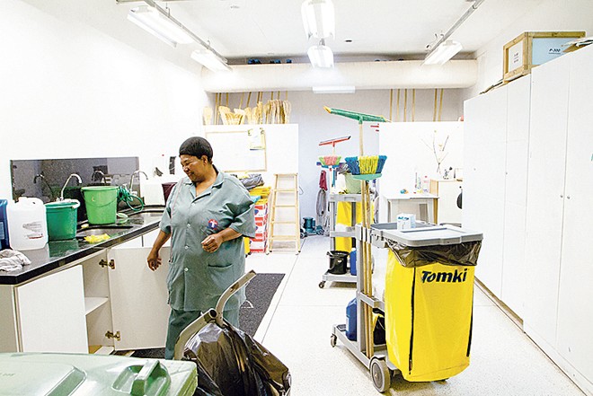 Na área de serviços, uma funcionária prepara o material que será utilizado na limpeza |