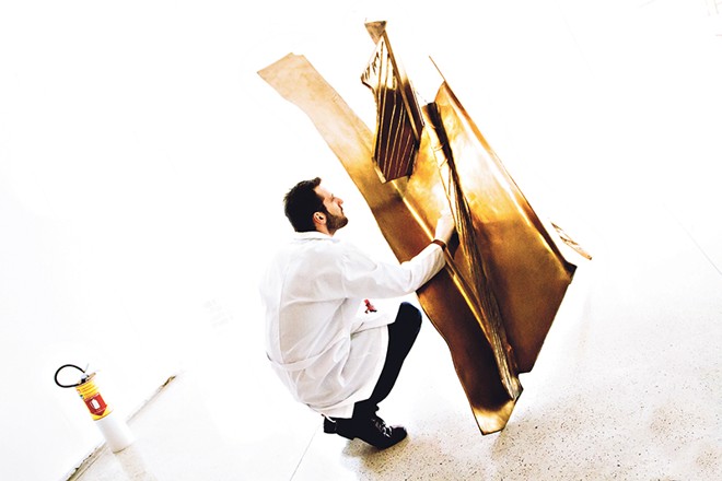 Humberto Imbrunisio, responsável pelo acervo do MON, se dedica à obra Amor à Primeira Vista, escultura de Maria Bonomi |