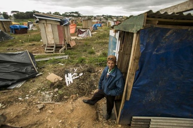 João Maria de Souza, em frente ao seu barraco | 
