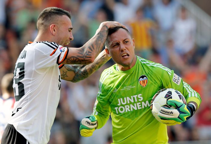 Goleiro brasileiro Diego Alves, do Valência, é cumprimentado pelo argentino Nicolás Otamendi após defender pênalti do Atlético de Madrid | EFE