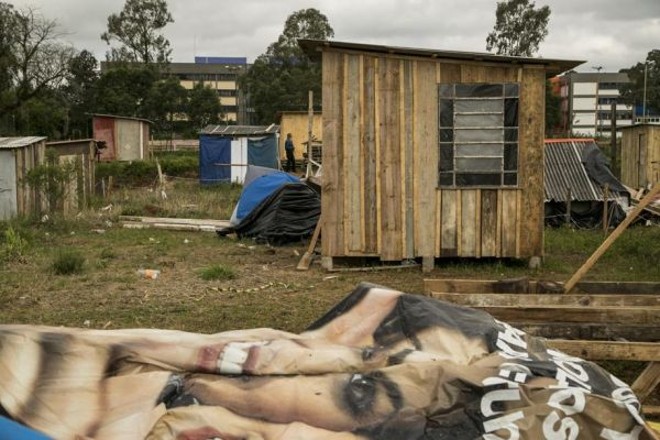 Lona usada em campanha política servirá de material para construir barraco. Ao fundo, a Universidade Positivo | 