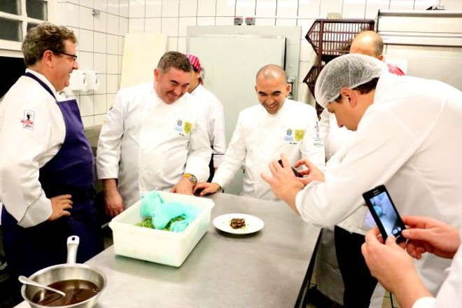 Os chefs admiram um dos pratos na cozinha |