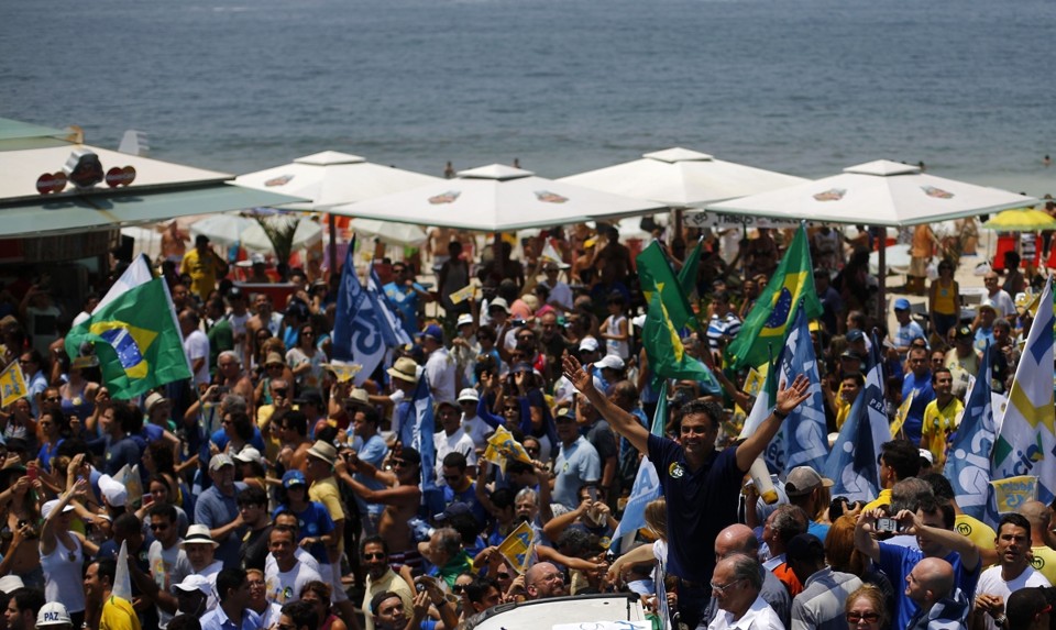 De um carro, Aécio acena para as centenas de pessoas que acompanharam sua caminhada no Rio | Reuters/Ricardo Moraes
