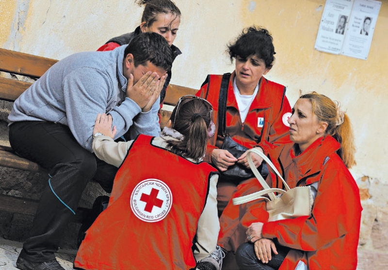 Uma equipe da Cruz Vermelha búlgara conforta os familiares dos operários da fábrica de Midzhur | Vassil Donev/European Pressphoto Agency