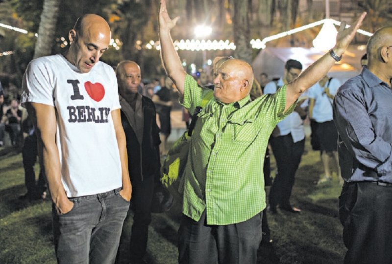 Dois israelenses conversam em Tel Aviv sobre migração | URIEL SINAI para THE NEW YORK TIMES