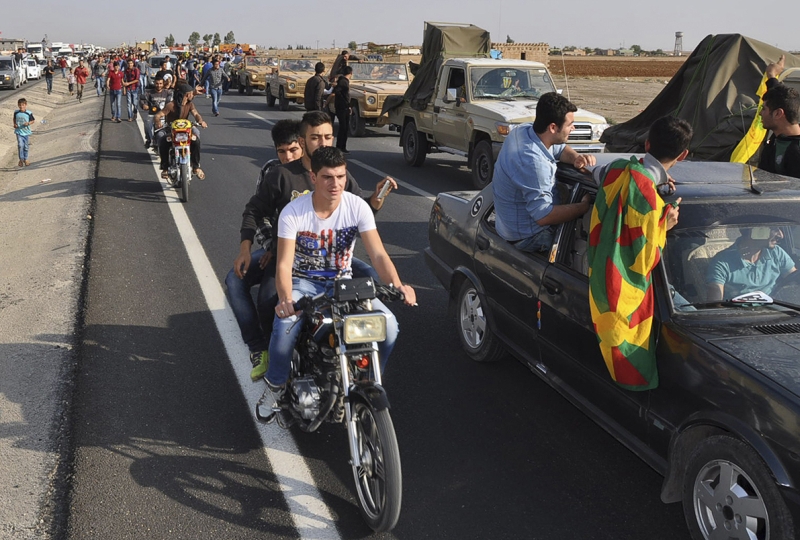 Comboio de veículos do exército peshmerga escoltado por curdos a caminho da fronteira da Síria com a Turquia | Reuters