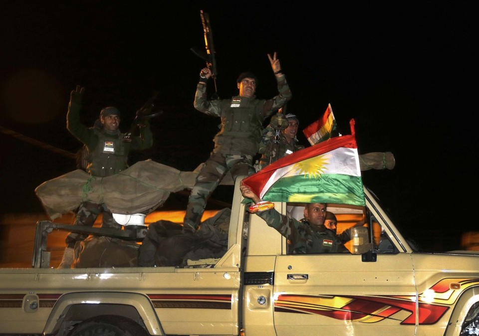 Comboio de veículos de "peshmergas", forças curdo-iraquianos, chegaram nesta sexta na fronteira com a cidade de Kobani | REUTERS / Yannis Behrakis