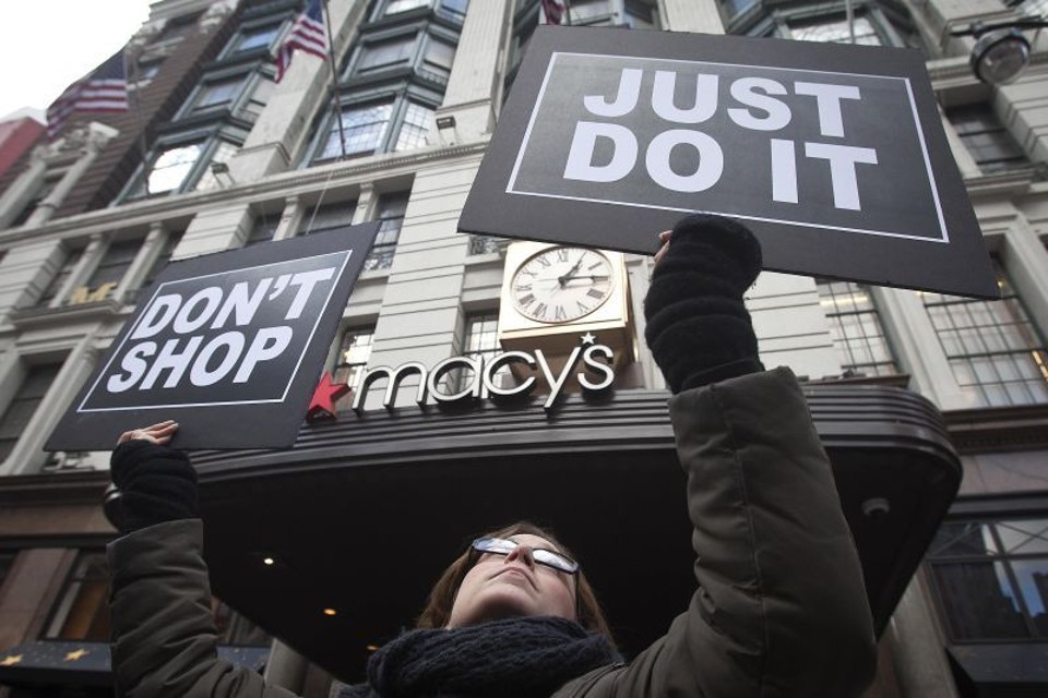 Manifesta segura cartaz em frente à loja da Macys em Nova York | Carlo Allegri/Reuters