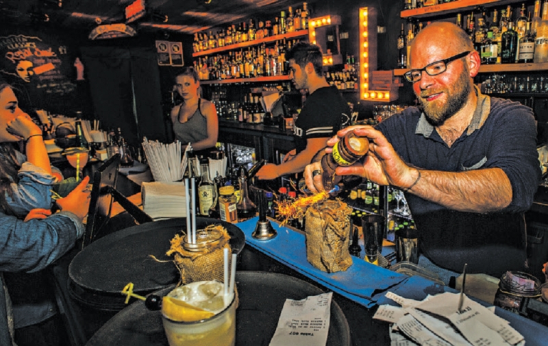 A variedade de coquetéis e a localização discreta na cobertura de um prédio comercial são as principais atrações do The Rook | Tony Sernack para The New York Times