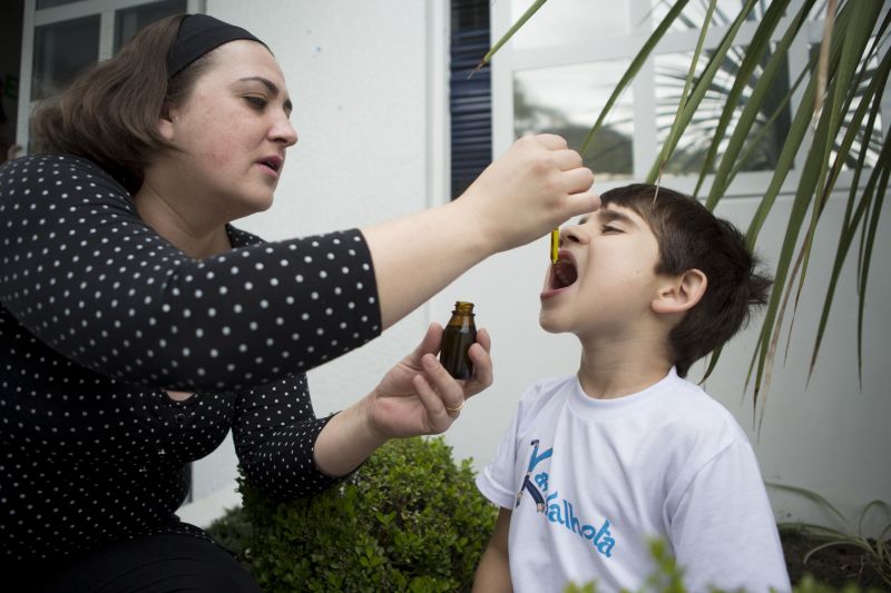 Priscila Inocente dá canabidiol ao filho, Miguel, de 5 anos. No início deste ano, em meio às dificuldades para importar o remédio, ela mesma produziu a substância em casa | Henry Milléo/Gazeta do Povo