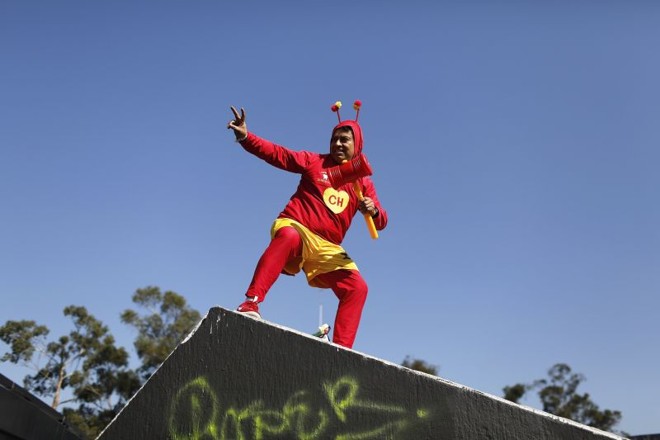 Homem vestido de Chapolin Colorado posa para foto enquanto aguarda para entrar no estádio Azteca |