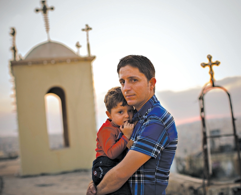 Radwan Shamra e o filho Martin. Esperança de que sua comunidade cristã sobreviva à guerra | warrick page para The New York Times