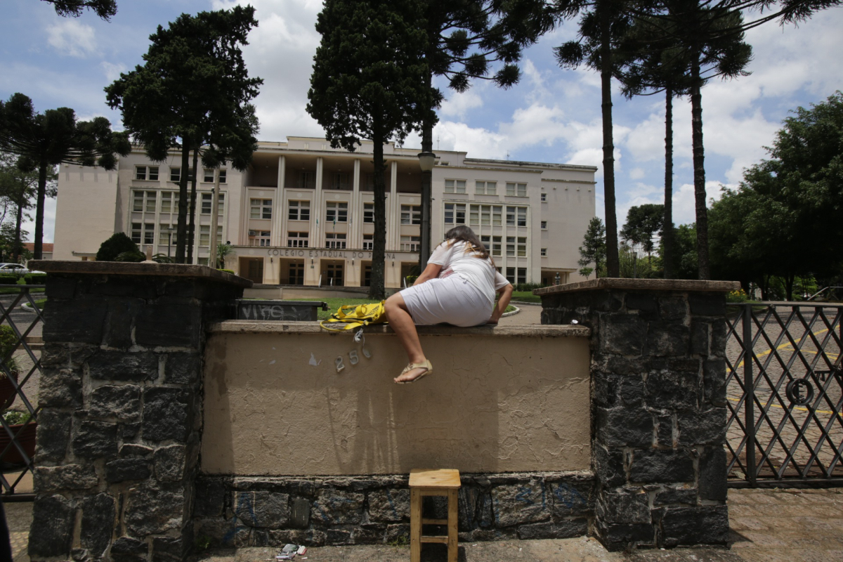 Candidata atrasada tenta entrar no Colégio Estadual do Paraná após o fechamento dos portões. | Daniel Castellano / Agência de Notícias Gazeta do Povo