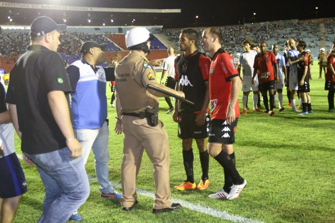 Policial faz a parede entre jogadores do Brasil e integrante da comissão técnica do Londrina. | 