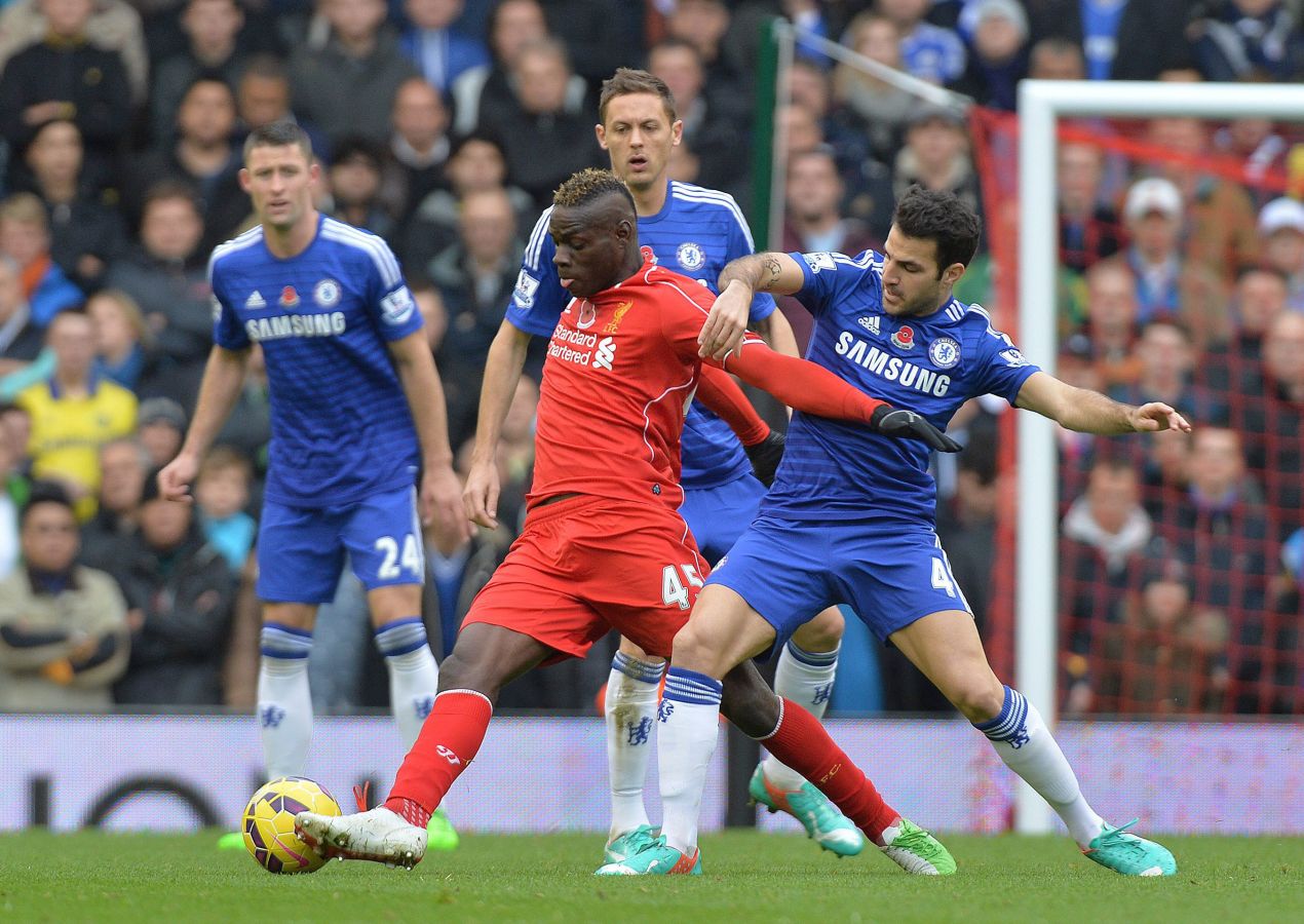 Mario Balotelli (esquerda), do Liverpool, disputa bola com Cesc Fabregas, do Chelsea, durante jogo deste sábado | EFE/EPA/PETER POWELL