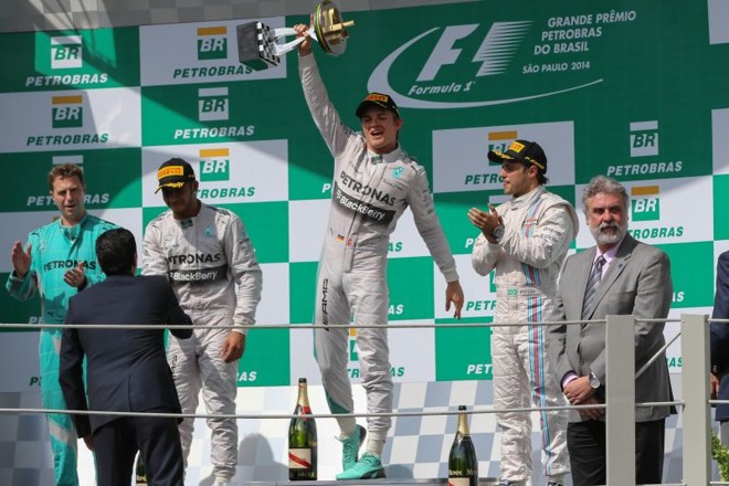 O piloto alemão Nico Rosberg ergue taça no pódio de Interlagos, ao lado do companheiro da Mercedes Lewis Hamilton (esquerda) e Felipe Massa, da Williams (direita) | 