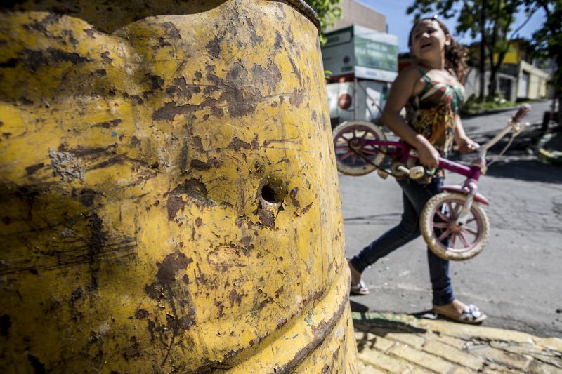 Criança brinca ao lado de uma marca de tiro numa rua da Vila Torres | Henry Milléo/ Gazeta do Povo