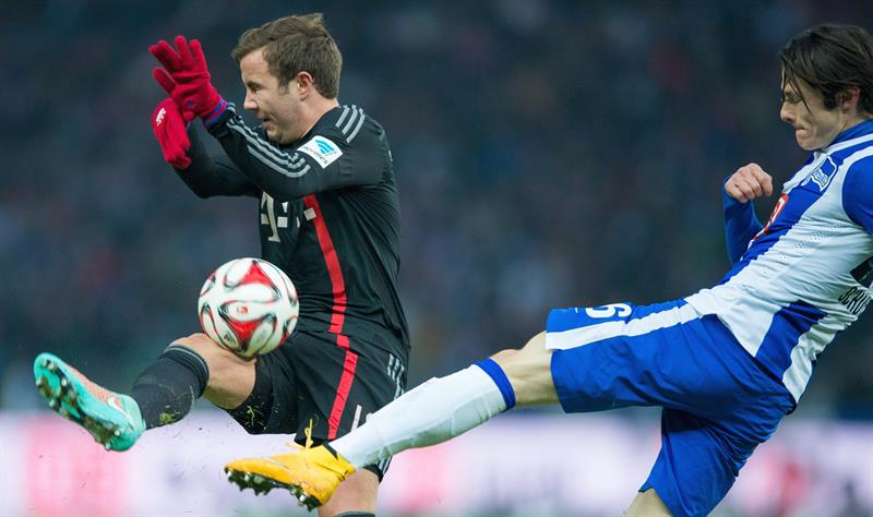 Mario Goetze (à esquerda), do Bayern, e Nico Schulz, do Hertha, brigam pela bola em partida pelo Campeonato Alemão | EFE/EPA/LUKAS SCHULZE