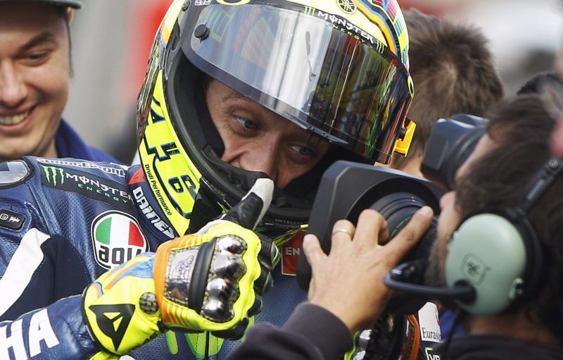 O piloto de MotoGP Valentino Rossi cumprimenta cinegrafista após conseguir melhor tempo em sessão de classificação | EFE/Kai Försterling