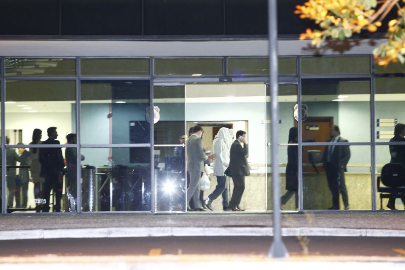 Preso (com o rosto coberto) deixa a sede da Polícia Federal em Curitiba, ontem à noite | Aniele Nascimento/Gazeta do Povo