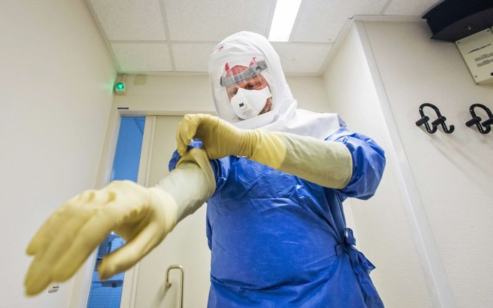 Médico se prepara para o tratamento de um paciente com ebola, doença que já matou mais de 13 mil pessoas | EFE/EPA/REMKO DE WAAL