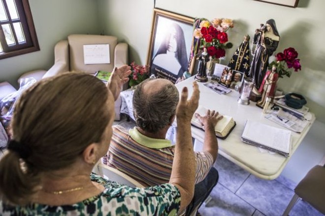 O ritual é o mesmo: enquanto dona Joana impõe as mãos sobre a pessoa, esta permanece com a mão direita sobre a Bíblia | 