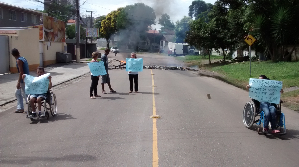 Moradores seguravam cartazes para protestar contra a falta de segurança para os pedestres na rua Felisbino Passos | Diego Ribeiro/Gazeta do Povo
